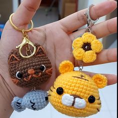 two crocheted keychains in the palm of someone's hand, one with a cat and another with a mouse