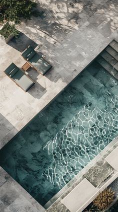 an aerial view of a swimming pool with lounge chairs