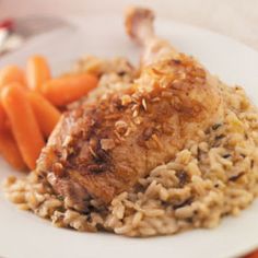 a white plate topped with meat and rice next to carrots