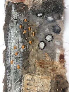 an altered piece of fabric with orange and black patches on the bottom, along with other material