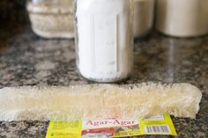 there are several jars on the counter and one is filled with sugary treats,