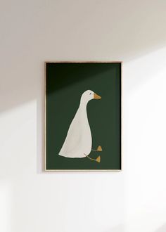 a white duck in a green frame hanging on the wall