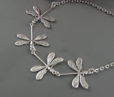 Four dragonflies necklace. Four flying dragonfly/butterfly/insect in one direction. Dragonflies are sterling silver plated. Connected to silver chain and heart toggle clasp. Feel free to pick different charms to either personalized or decorate the necklace: https://www.etsy.com/listing/91915088/personalized-initial-custom-add-on?ref=shop_home_active_2 https://www.etsy.com/listing/529516757/personalized-birthstone-custom-add-on? ref=shop_home_active_1 https://www.etsy.com/listing/600994579/person Flying Dragonfly, Dragonfly Wedding, Blue Stones Jewelry, Dragonfly Tattoo Design, Friend Anniversary, Jewelry Bride, Butterfly Insect, Birthday Sister, Celtic Earrings