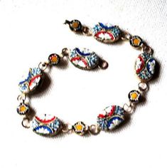 "Art nouveau vintage 40s , silvertone metal , hand made bracelet with a multi color mosaic design. Made in Italy. Large oval and small disc shape links. Blue, red, white , yellow color. Exotic, stylish, unique. Excellent condition. Clean and strong. No missing parts. You can use as a gift. Size 7 1/2 Length:7,5\" Size of the oval link:0,5\"x 0,3\" Size of the disc link: 0,25\" across Thank you for stopping!" Multicolor Nickel-free Retro Jewelry, Retro Multicolor Nickel-free Jewelry, Antique Multicolor Metal Jewelry, Vintage Multicolor Metal Jewelry, Ornate Multicolor Bracelets For Gifts, Vintage Multicolor Enamel Jewelry, Ornate Multicolor Bracelet For Gift, Handmade Multicolor Ornate Jewelry, Vintage Silver Beaded Round Bracelets