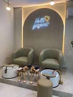 two chairs and a table in front of a sign that says hello gorgeous on the wall