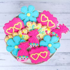 decorated cookies in the shape of flowers and hearts on a white wooden table with wood planks