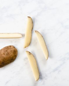 potatoes are cut up and placed on a white counter top with one potato in the middle