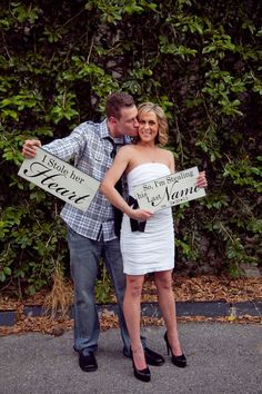 a man and woman posing for a photo holding signs that say yes to each other