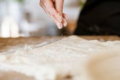 a person is kneading dough on a table