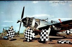 an old airplane with checkered flags sitting on the ground in front of it's propeller