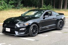 a black mustang parked in a parking lot