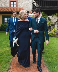 two men and a woman walking down a brick path