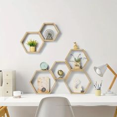 three hexagonal shelves on the wall above a white desk