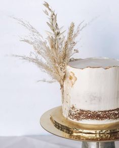 a cake with white frosting and brown sprinkles on a gold plate