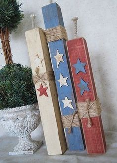 three wooden stars are tied together with twine on top of each other in front of a potted plant