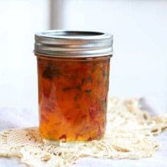 a glass jar filled with food sitting on top of a white tablecloth covered floor