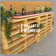 the pallets wonders logo is displayed on top of a wooden table with bottles and glasses