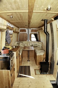 the interior of a small camper with wood trimmings and wooden flooring