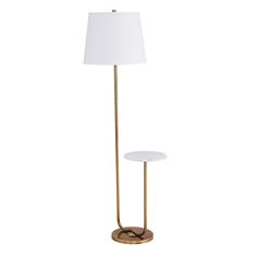 a floor lamp with a white shade on it and a gold stand next to it