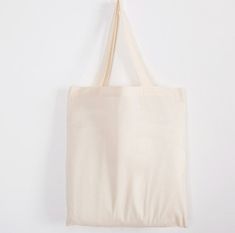 a tote bag hanging up against a white wall with the bottom part of it's handle