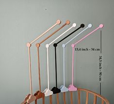 four wooden hooks hang on the wall with different colors and shapes, including one hook