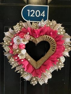 a heart shaped wreath is hanging on a door with a sign that reads 1204