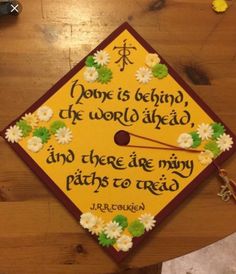 a graduation cap with flowers on it that says, done is being the world ahead and there are many paths to reach