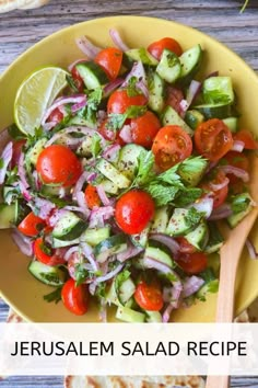 a salad with tomatoes, cucumbers and onions in a yellow bowl next to pita bread