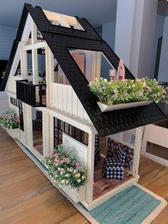 a doll house with flowers in the windows