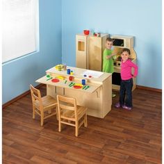 two children are playing in a play kitchen