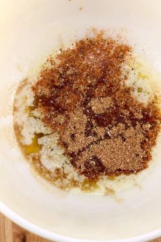 a white bowl filled with spices on top of a wooden table