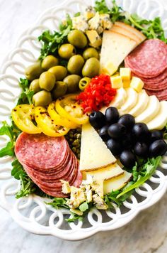 a platter filled with meat, cheese and olives