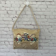 a gold purse hanging on a brick wall