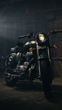 a motorcycle parked in a dark room with lights on it's headlamps