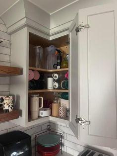 an open cabinet in the corner of a kitchen