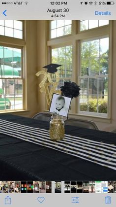 a table topped with a vase filled with flowers and a graduation cap on top of it