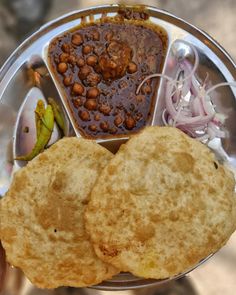 a person holding a metal plate with food on it