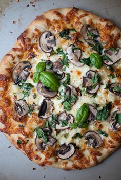 a pizza with mushrooms, garlic and spinach on it