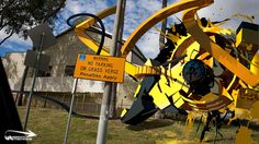 a yellow and black street sign sitting on the side of a road next to a building