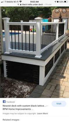 a white deck with black railings next to a swimming pool