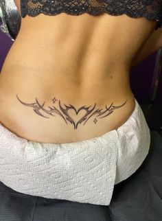 a woman's lower back tattoo with birds and hearts on her side, in black ink