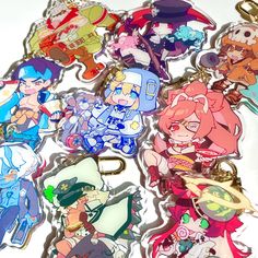 several anime keychains are shown on a white surface, with various characters in the background