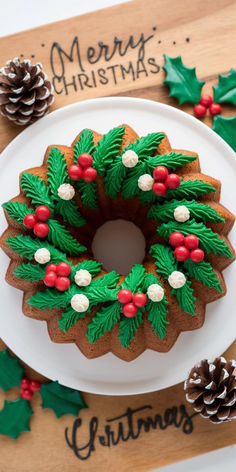 a christmas wreath shaped cookie on a plate with pine cones and holly leaves around it