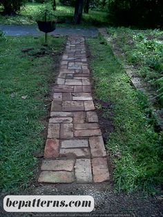 a brick path in the middle of a grassy area