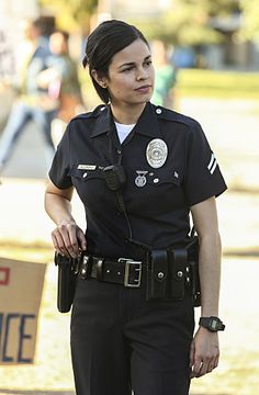 a woman police officer is standing in the street