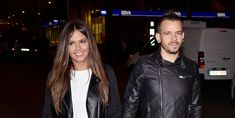 a man and woman are walking down the street at night with their hands in each others'pockets