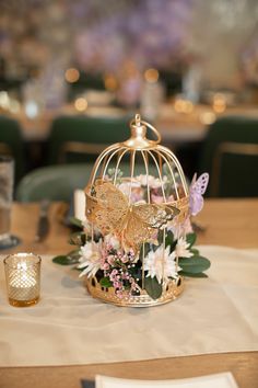 a birdcage filled with flowers on top of a table