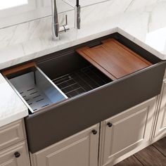 a kitchen sink with an open drawer in the middle and white marble countertops on both sides