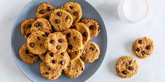 a plate full of chocolate chip cookies next to a glass of milk