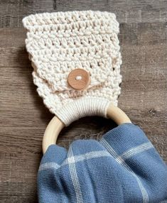 a wooden ring with a white knitted bag on it's end and a blue plaid cloth